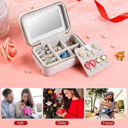 Jewelry box with compartments on a pink background with decorative elements.