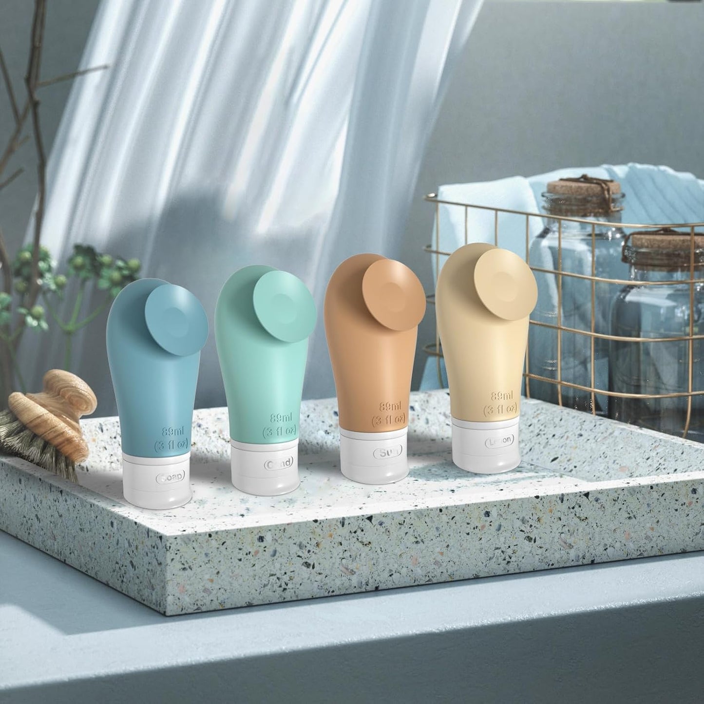 Four travel bottles on a stone surface with a blurred background