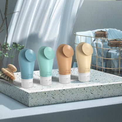 Four travel bottles on a stone surface with a blurred background